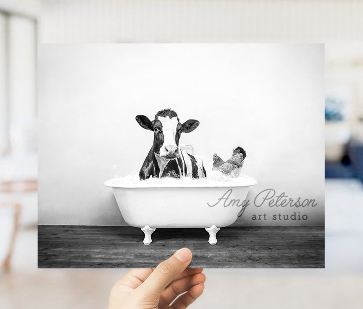 a black and white photo of two cows in a bathtub