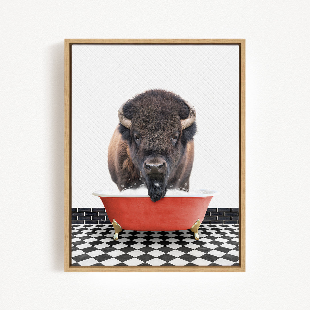 A buffalo with large horns is standing in a red bathtub filled with water, creating a whimsical and humorous scene.