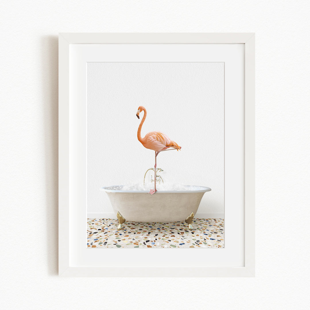 A framed image of a flamingo standing on one leg inside a white bathtub.