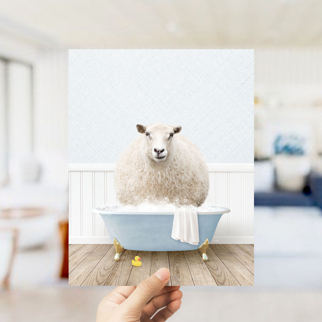 A fluffy white sheep sits in a blue bathtub filled with bubbles, surrounded by a white towel and a yellow rubber duck.