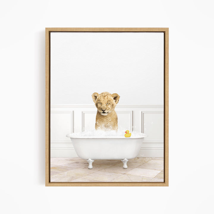 A young lion cub sitting in a white bathtub, surrounded by bubbles and a rubber duck.
