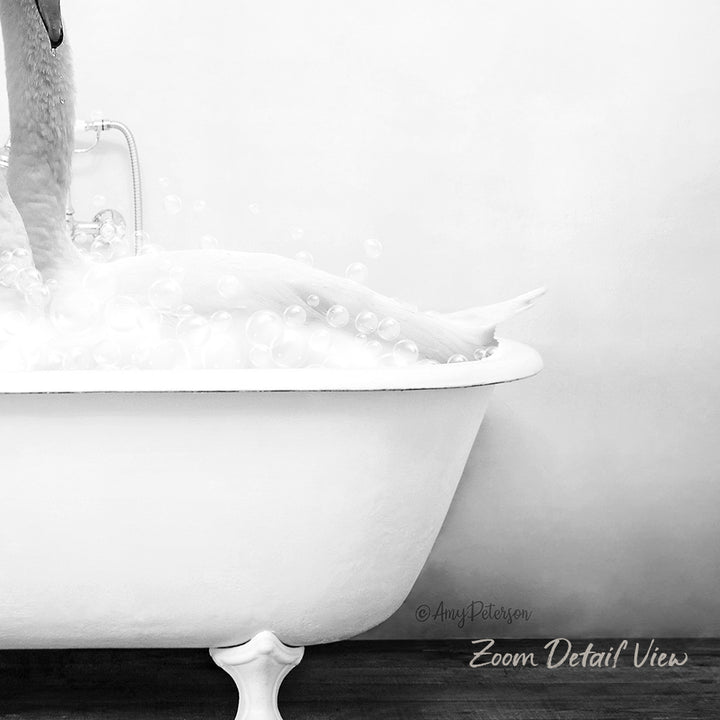A person is taking a bath in a white bathtub, surrounded by bubbles, in a black and white image.
