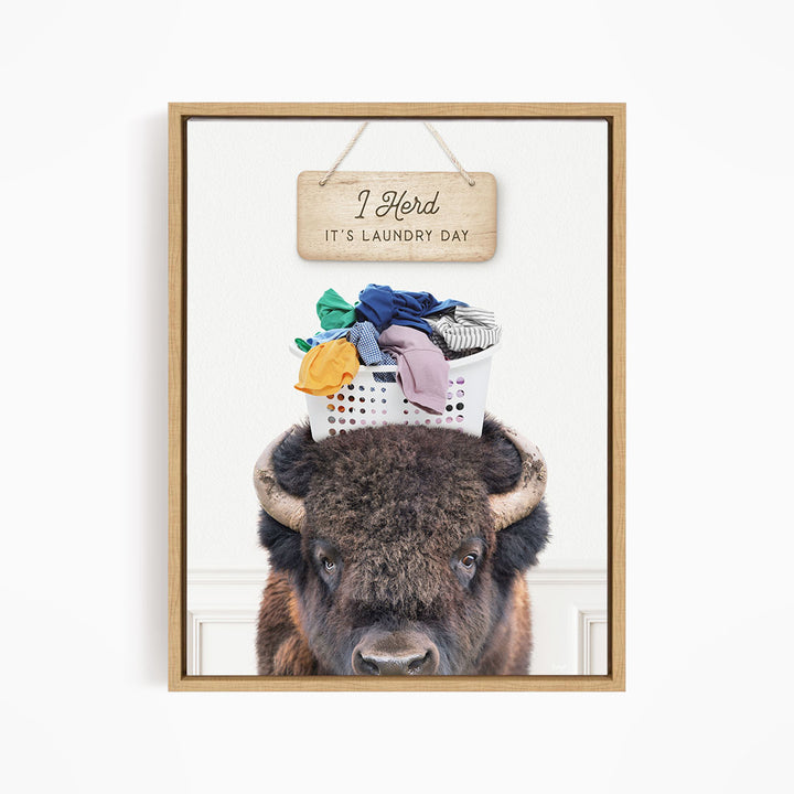 A buffalo with a basket of laundry on its head, accompanied by a wooden sign that says "It's laundry day".
