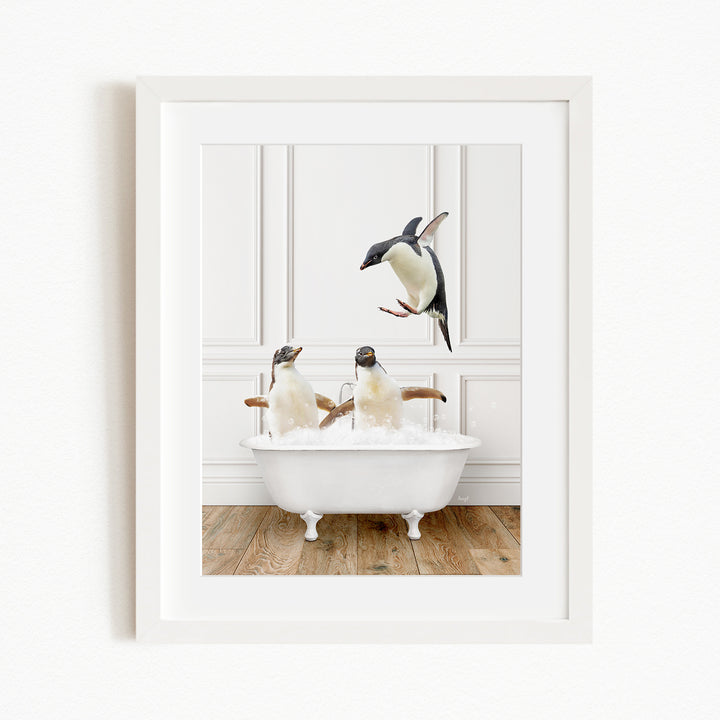 A framed image depicting two penguins sitting in a white bathtub, with one penguin flying towards the other.
