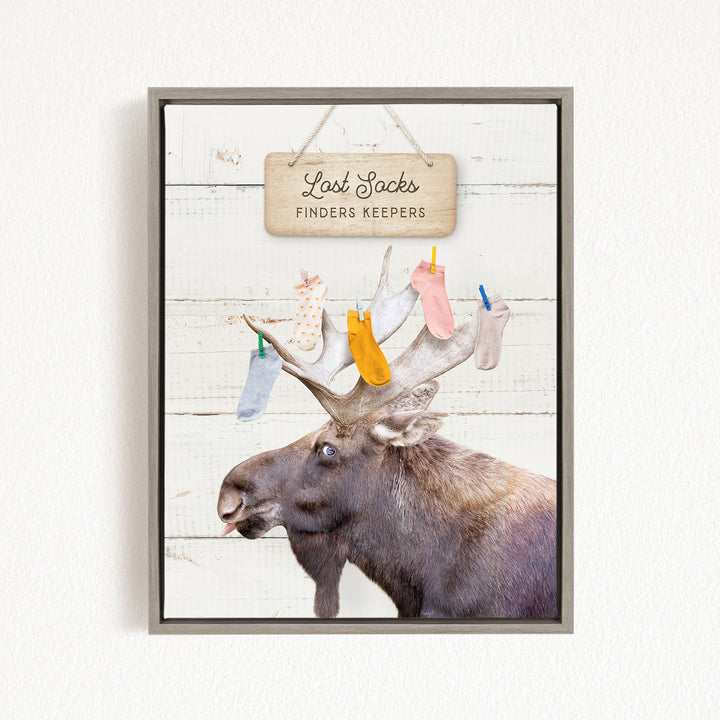 A framed image of a moose with a sign above it that says "Lost Socks Finders Keepers".