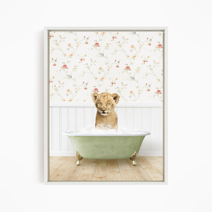 A young lion cub sitting in a green bathtub filled with water, with a floral wallpaper in the background.