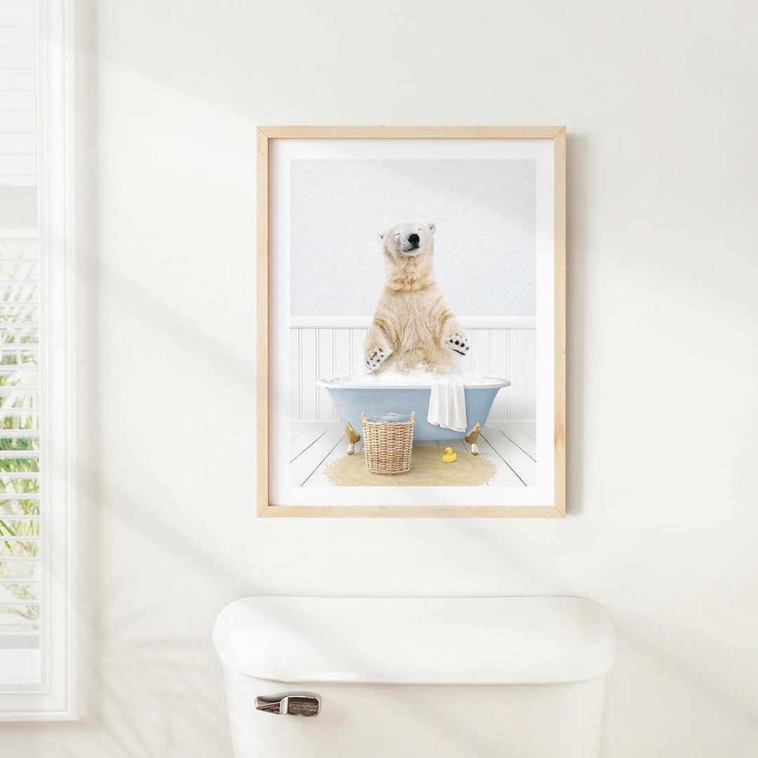 A polar bear standing in a bathtub, with a basket of toys nearby, is the central focus of the framed image displayed on the wall.