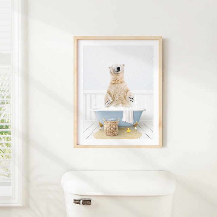 A polar bear standing in a bathtub, with a basket of toys nearby, is the central focus of the framed image displayed on the wall.