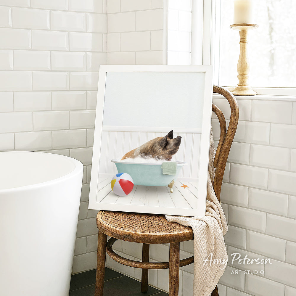 A framed image of a pig sitting in a bathtub, surrounded by a beach ball and a towel, is displayed on a wooden chair in a bathroom setting.