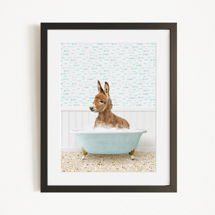 A donkey is sitting in a bathtub filled with water, surrounded by a patterned wall.