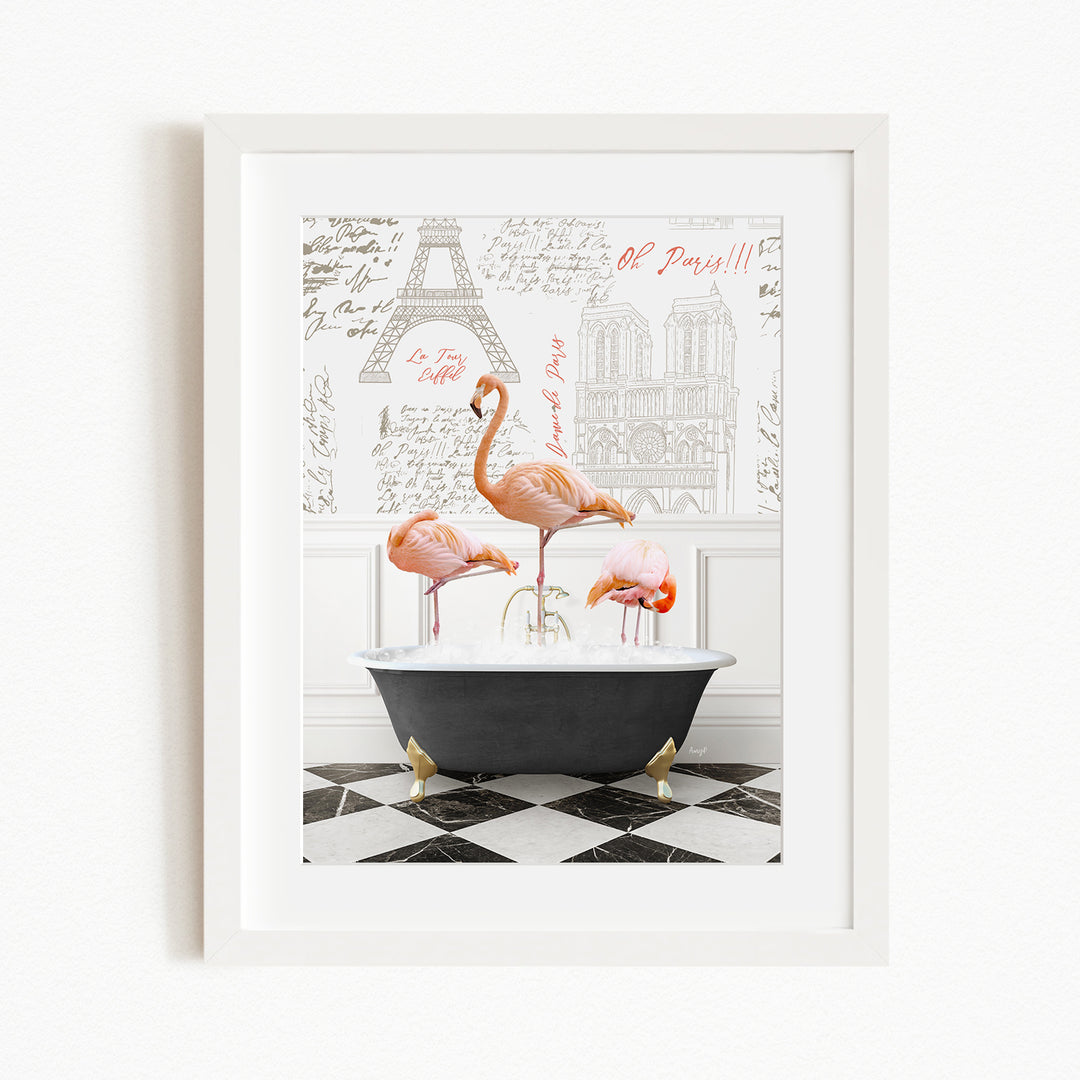 A framed image depicting three pink flamingos standing in a bathtub, with a black and white checkered floor and a Paris-themed background.