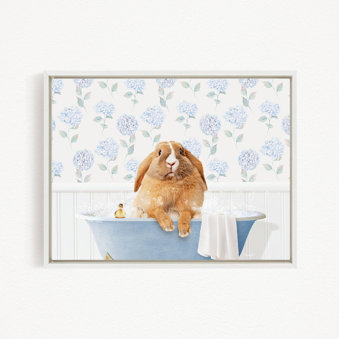 A brown rabbit sitting in a blue bathtub filled with bubbles, surrounded by a floral patterned wall.