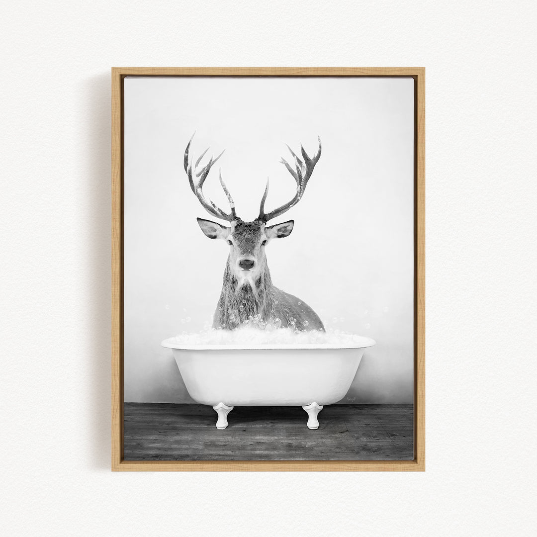 A deer with large antlers is sitting in a white bathtub filled with water, creating a whimsical and unexpected scene.
