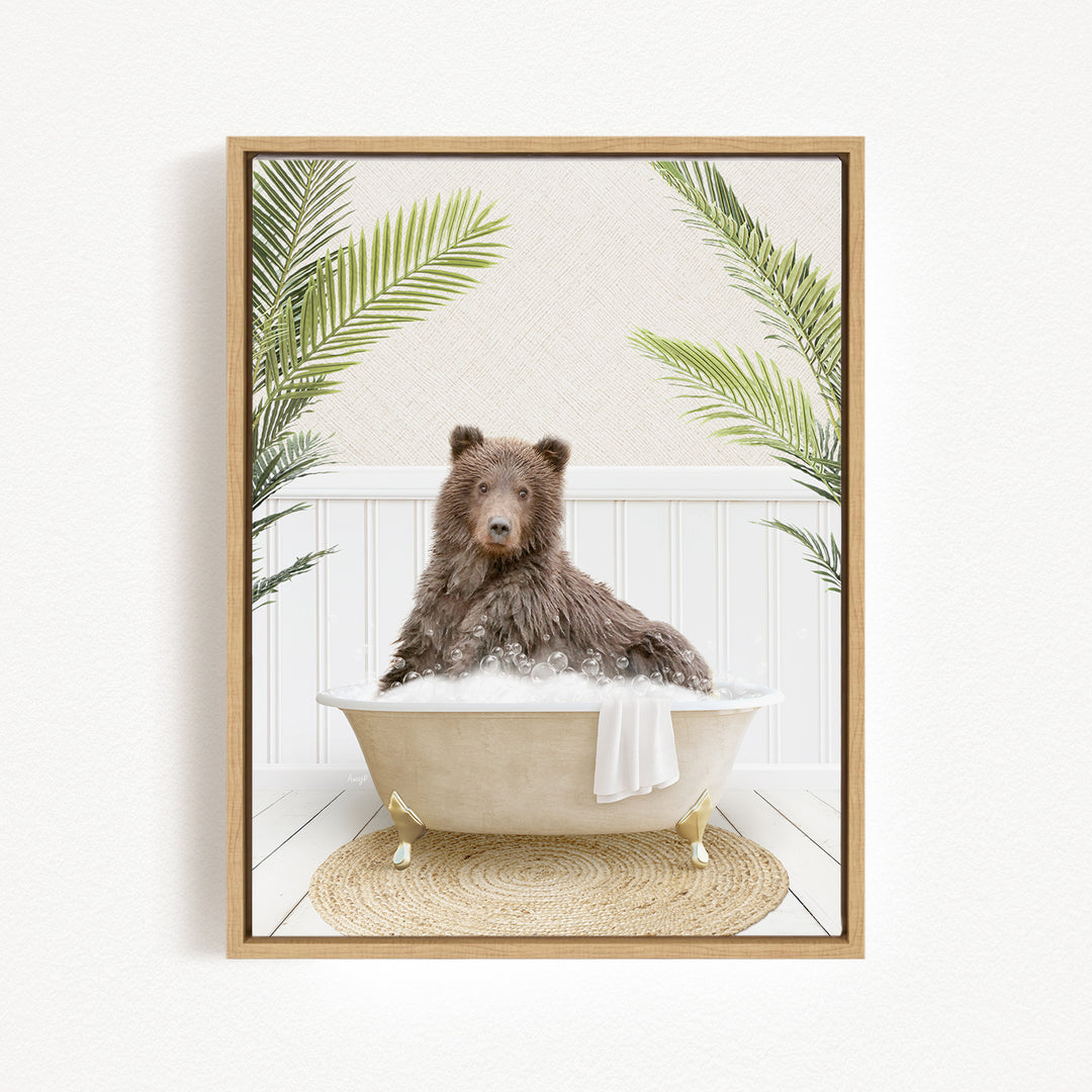 A brown bear sitting in a bathtub filled with bubbles, surrounded by green palm leaves.