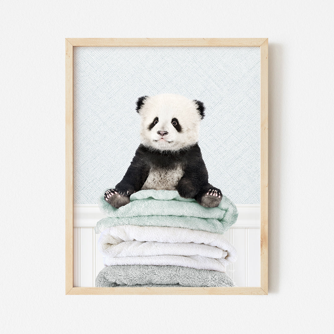 a panda bear sitting on top of a pile of towels