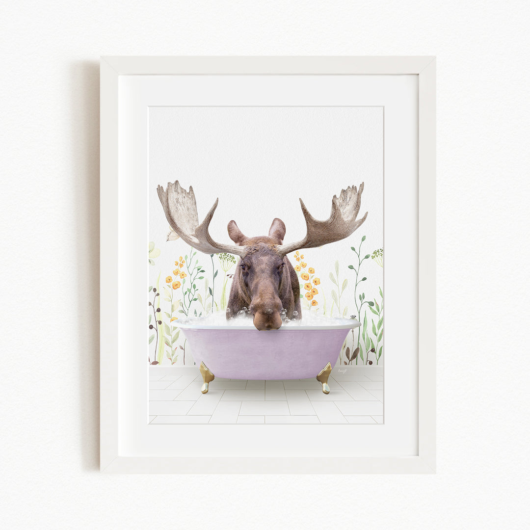 A moose with large antlers is sitting in a purple bathtub, surrounded by flowers and plants.
