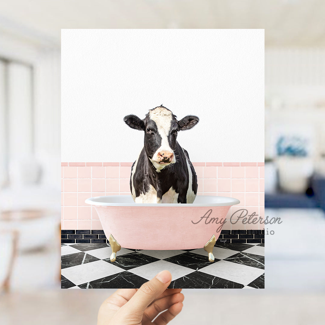 a person holding up a card with a picture of a cow in a bathtub