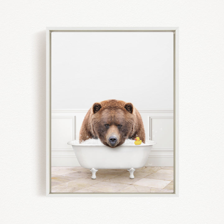 A brown bear is sitting in a white bathtub, surrounded by a yellow rubber duck.