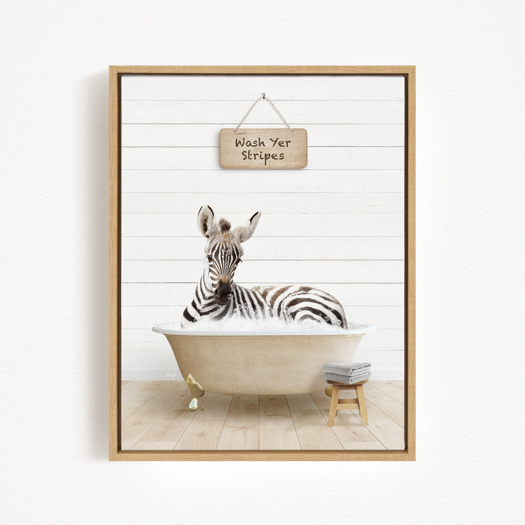A zebra is sitting in a bathtub, with a sign above it that says "Wash Yer Stripes".