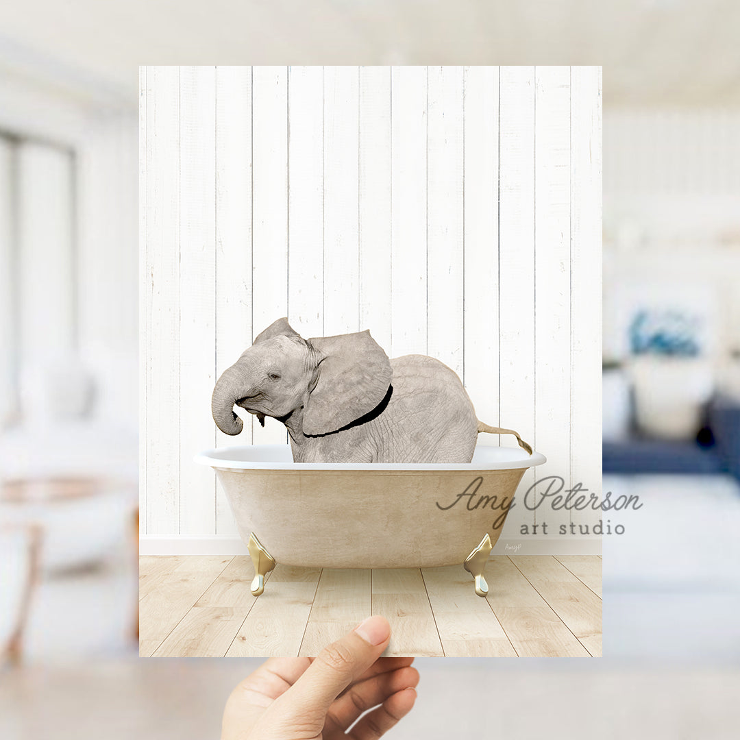 a hand holding a photo of an elephant in a bathtub