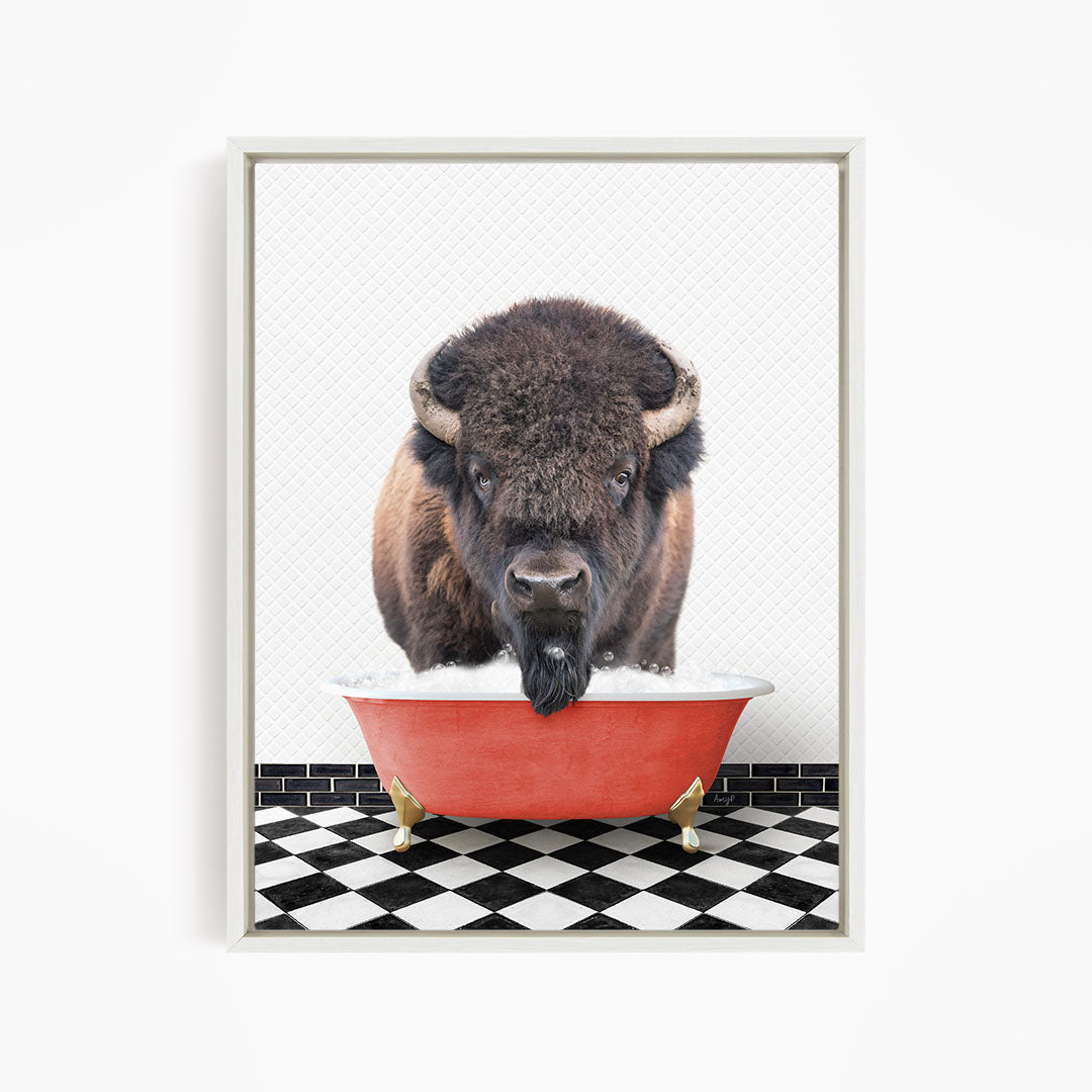 A buffalo with large horns is standing in a red bathtub, with a black and white checkered floor in the background.