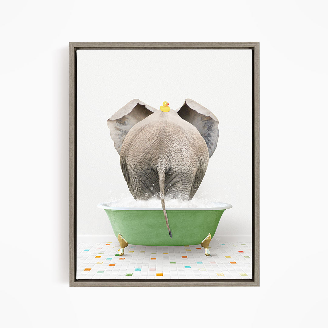 An elephant is taking a bath in a green tub, with a yellow rubber duck floating on its head.
