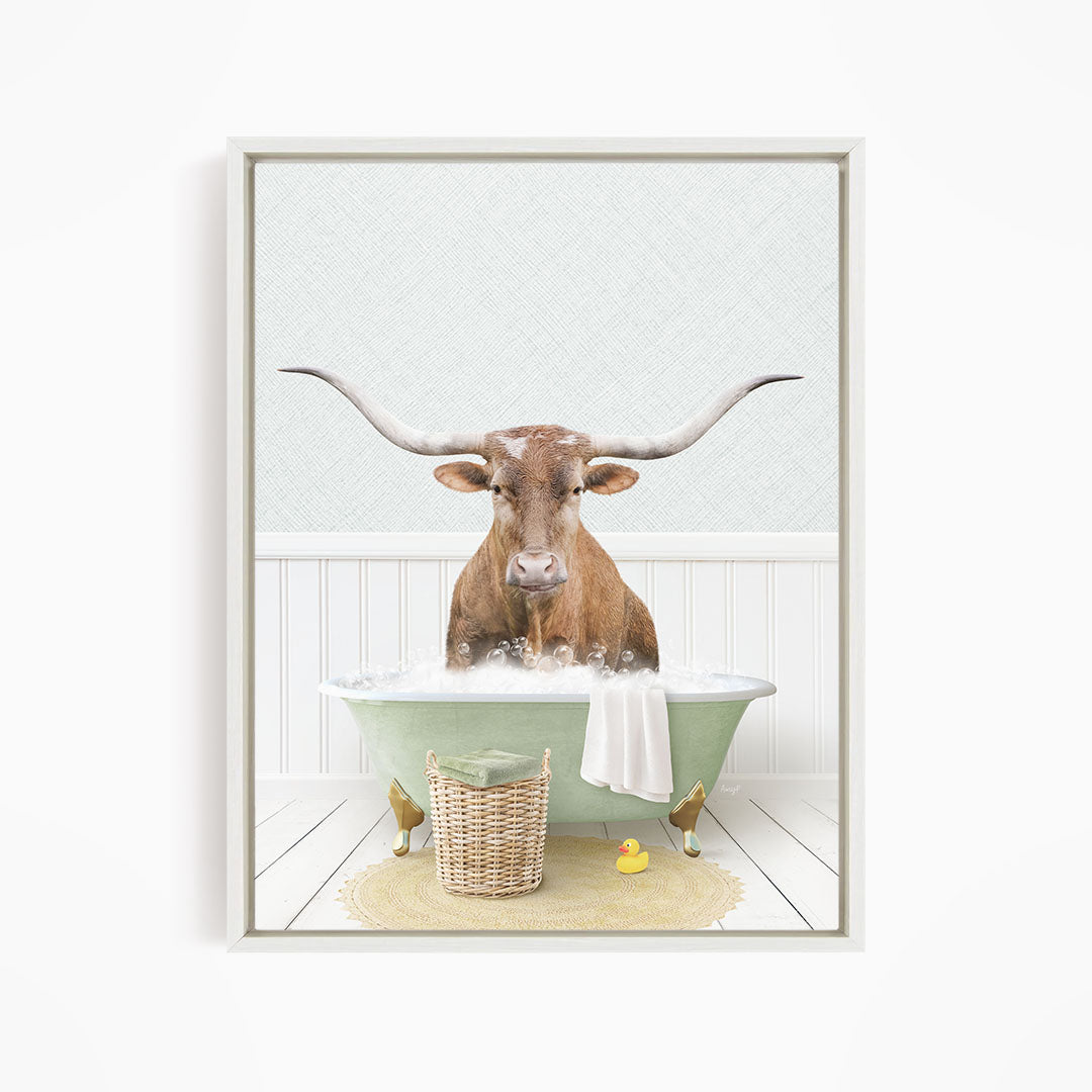 A brown bull with long horns is sitting in a green bathtub filled with water, surrounded by a yellow rubber duck and a basket.