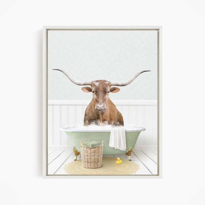 A brown bull with long horns is sitting in a green bathtub filled with water, surrounded by a yellow rubber duck and a basket.