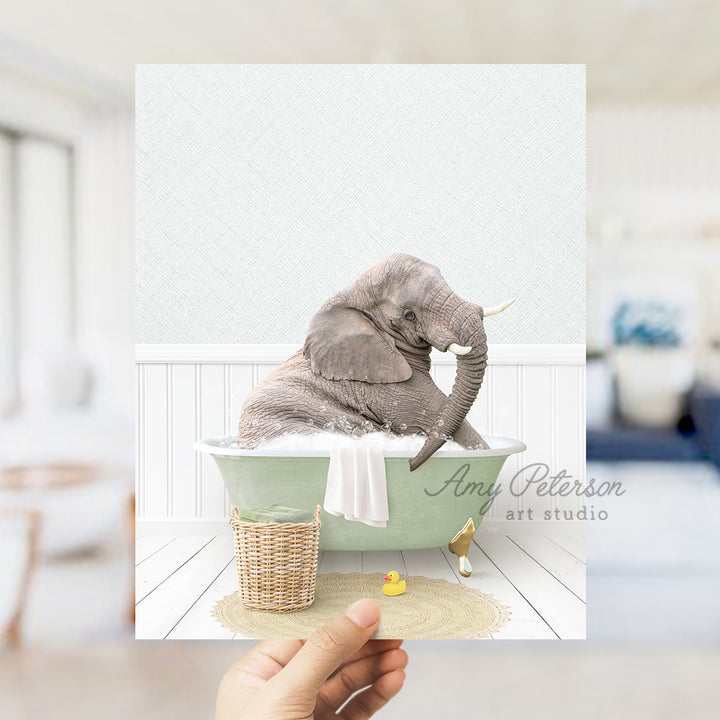 a person holding up a picture of an elephant in a bathtub