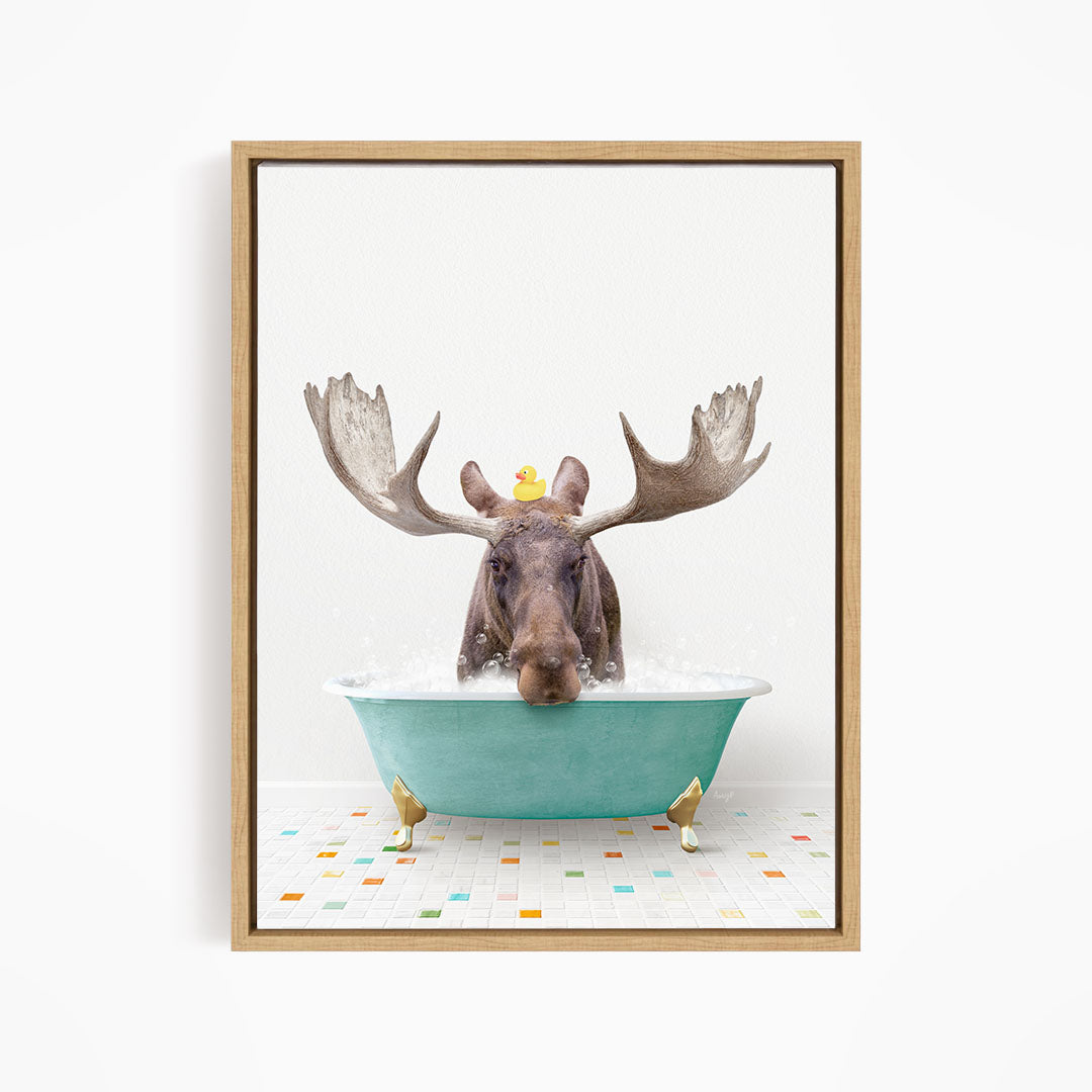 A moose with large antlers is sitting in a blue bathtub, with a rubber duck floating on its head.