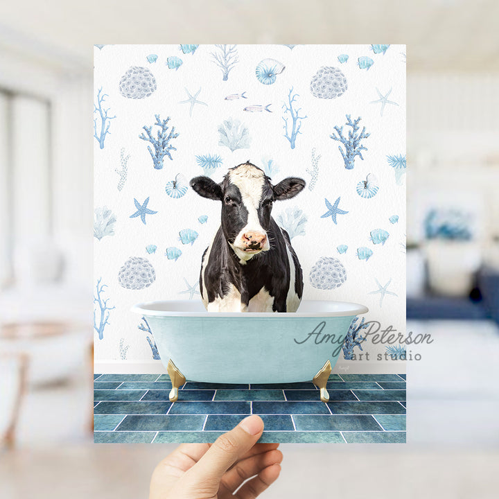 a hand holding up a card with a picture of a cow in a bathtub