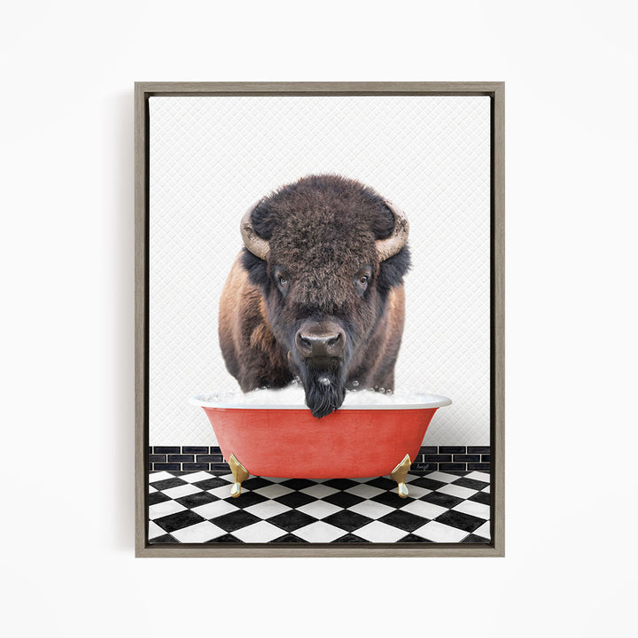 A buffalo with large horns is standing in a red bathtub filled with water, creating a whimsical and humorous scene.