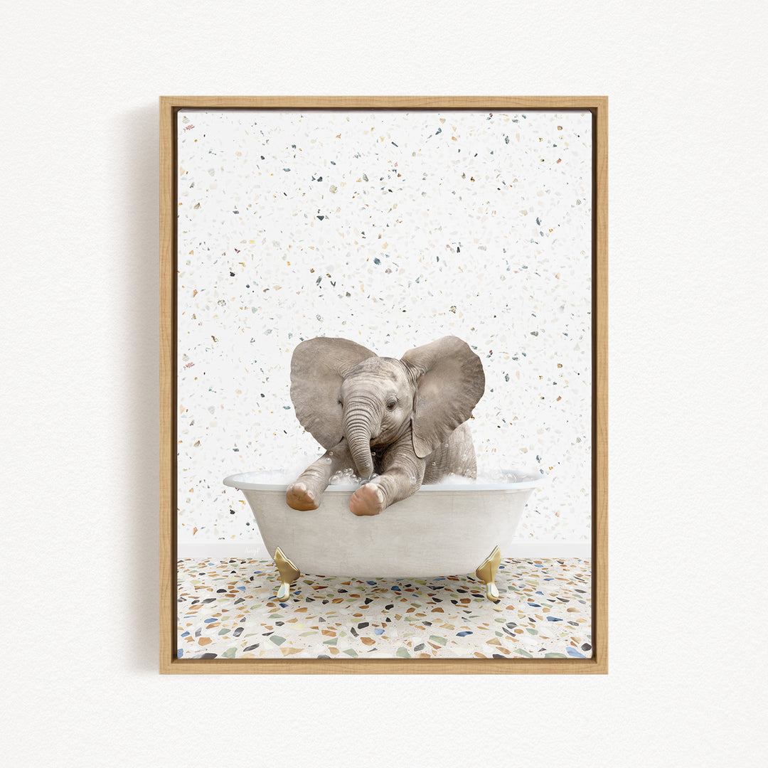 A baby elephant sitting in a white bathtub, with its trunk in the water, against a speckled white background.