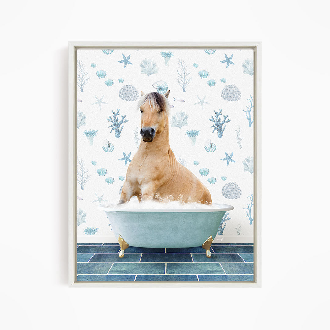 A light brown horse is sitting in a blue bathtub filled with water, surrounded by a pattern of blue and white seashells and starfish.