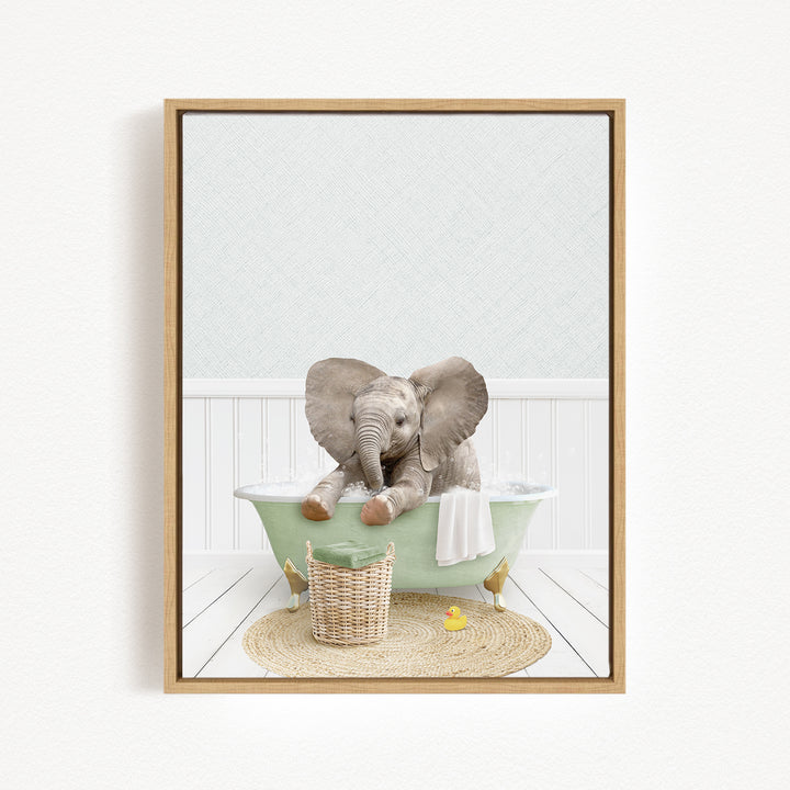 A baby elephant sitting in a green bathtub, surrounded by a basket of toys and a yellow rubber duck.