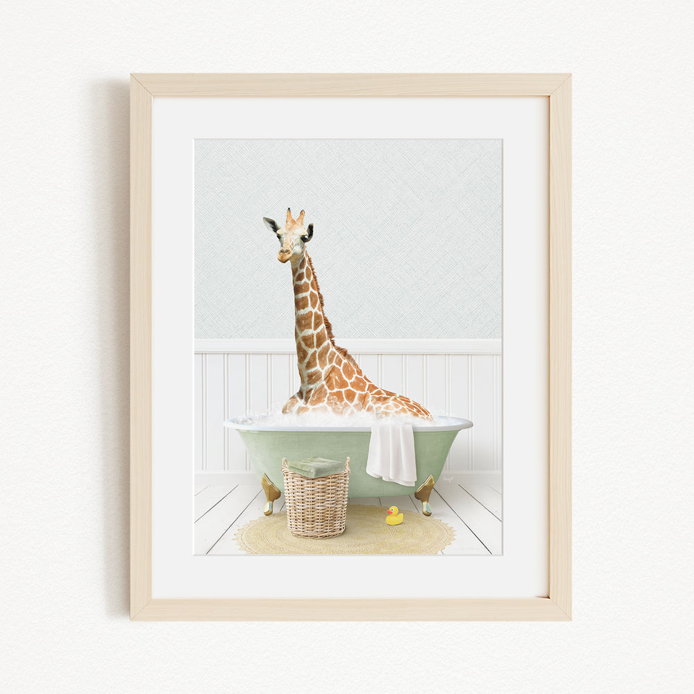 A giraffe sitting in a green bathtub filled with water, surrounded by a basket of toys and a yellow rubber ducky.