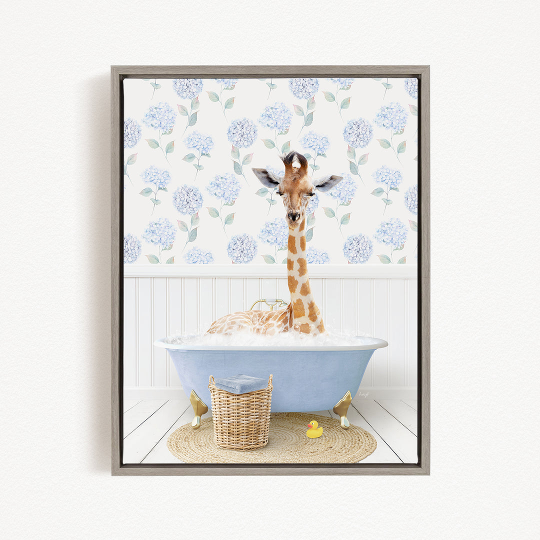 A giraffe is sitting in a blue bathtub filled with water, surrounded by a wicker basket and a rubber duck.