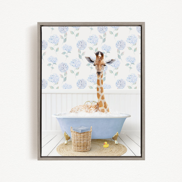 A giraffe is sitting in a blue bathtub filled with water, surrounded by a wicker basket and a rubber duck.