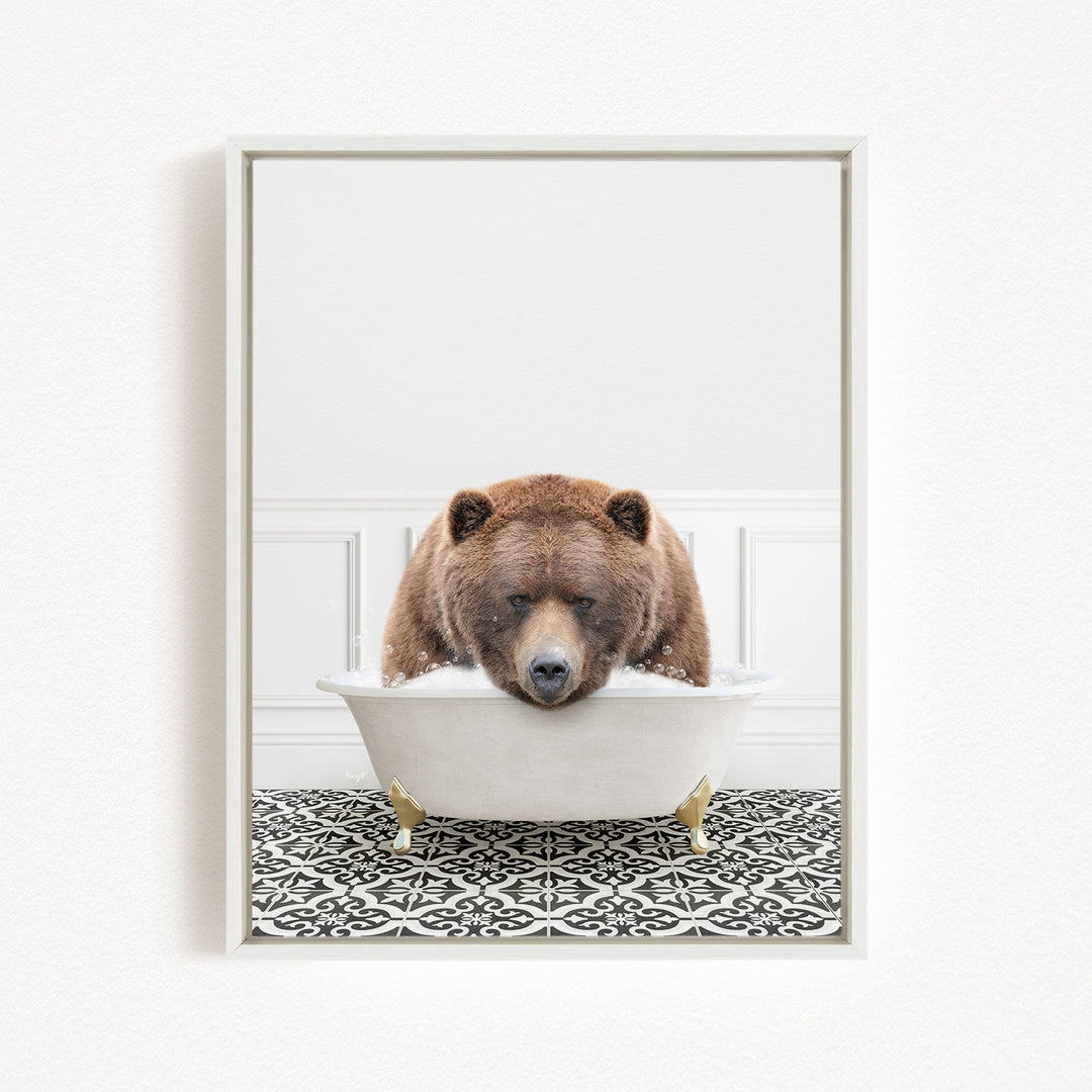 A brown bear is sitting in a white bathtub filled with water, appearing to be enjoying a relaxing bath.