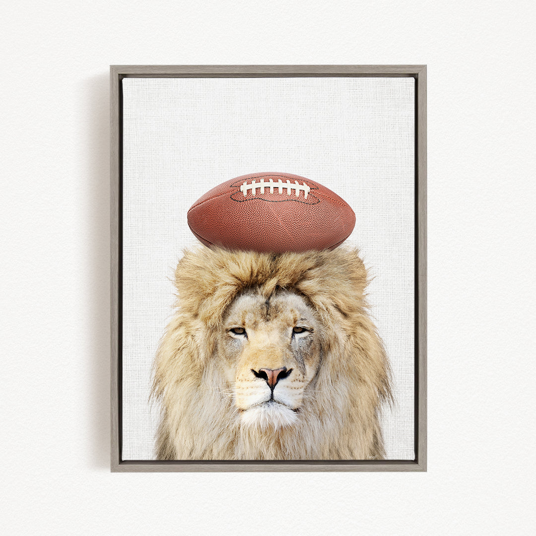 A lion with a football on its head, wearing a serious expression, is the central focus of the image.