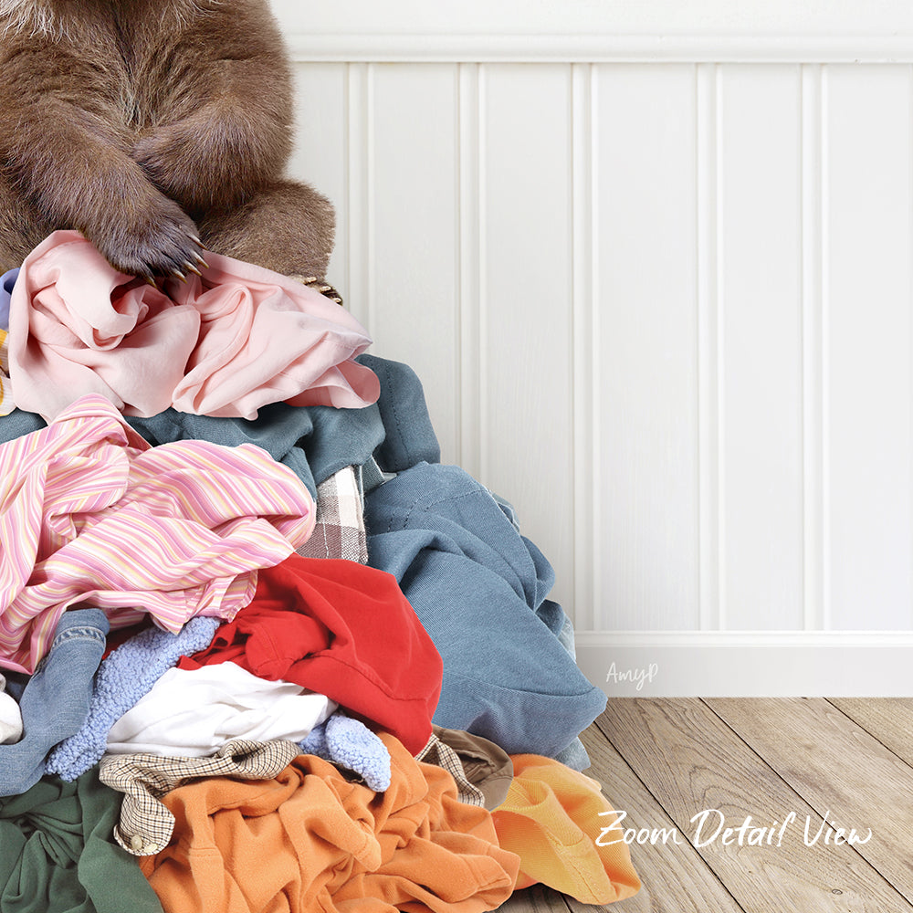 A pile of clothes, including various garments and linens, is stacked against a white wall.