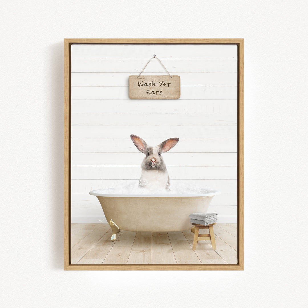 A white rabbit sitting in a bathtub filled with water, with a sign above that reads "Wash Your Ears".