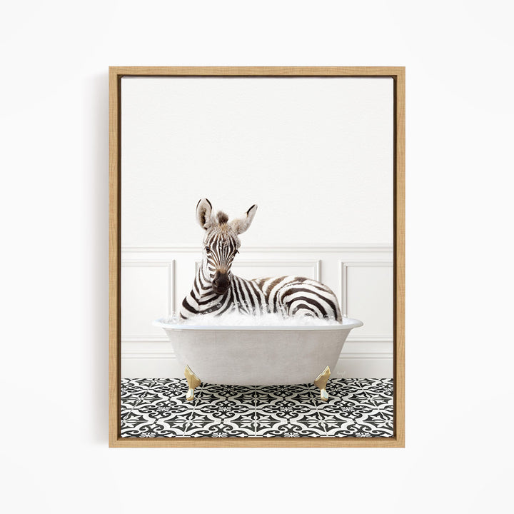 A zebra is sitting in a white bathtub, surrounded by a black and white patterned floor.
