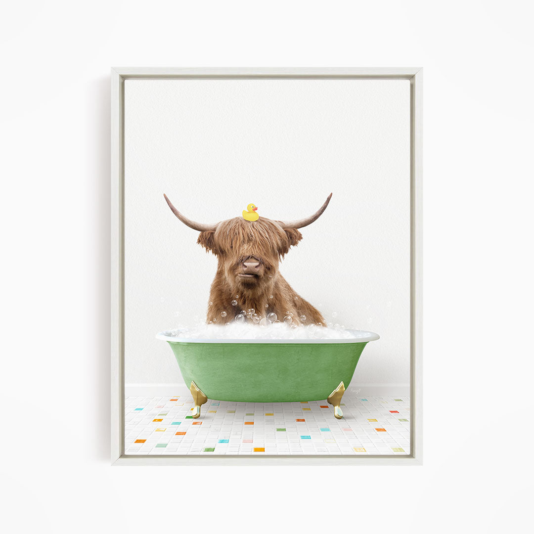 A Highland cow with long horns is sitting in a green bathtub filled with bubbles, with a rubber duck perched on its head.