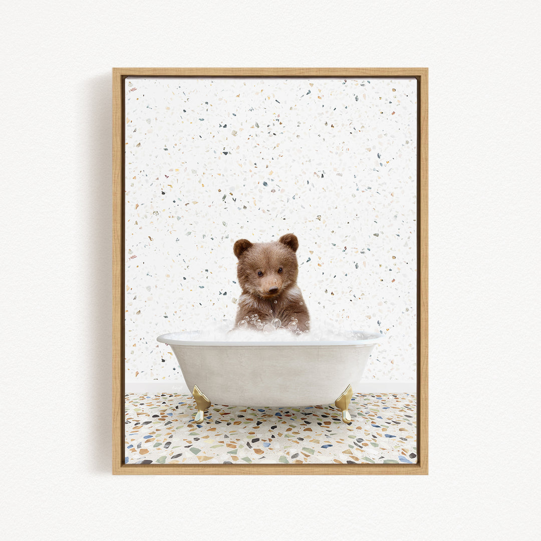 A cute brown bear sitting in a white bathtub filled with water, surrounded by a speckled white background.