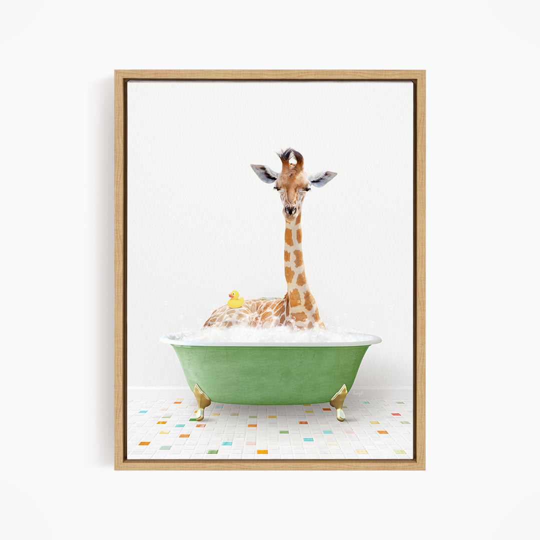 A giraffe is sitting in a green bathtub filled with bubbles, with a yellow rubber duck floating nearby.