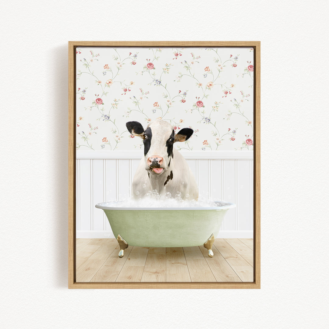 A black and white cow is sitting in a green bathtub filled with water, surrounded by a floral wallpaper.