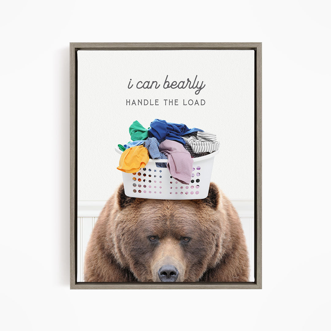 A brown bear sits on top of a laundry basket filled with clothes, with the text "I can bearly handle the load" written above the bear.