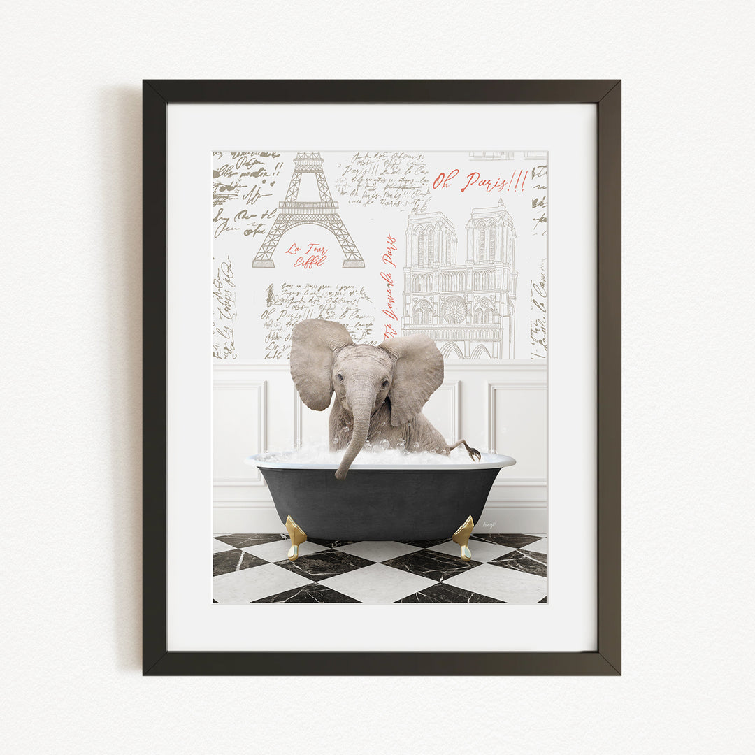 A framed image depicting an elephant sitting in a bathtub filled with water, with a Paris-themed background behind it.
