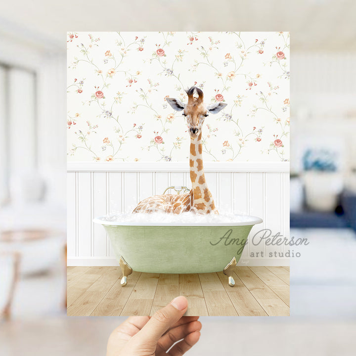 a hand holding up a picture of a giraffe in a bathtub